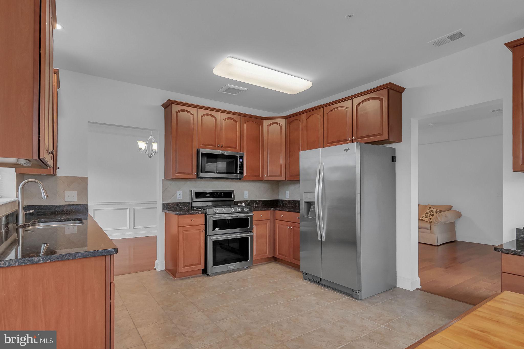 10273A Fountain Circle, Unit 306 Manassas, VA 20110 - Photo 16 of 33 a kitchen with stainless steel appliances granite countertop a refrigerator stove and sink