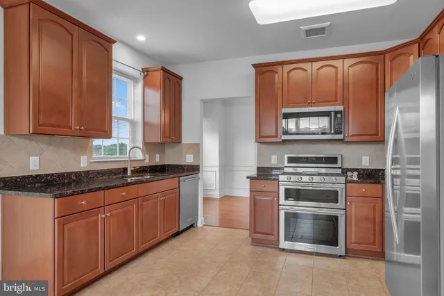 a kitchen with stainless steel appliances granite countertop a stove top oven a sink and dishwasher