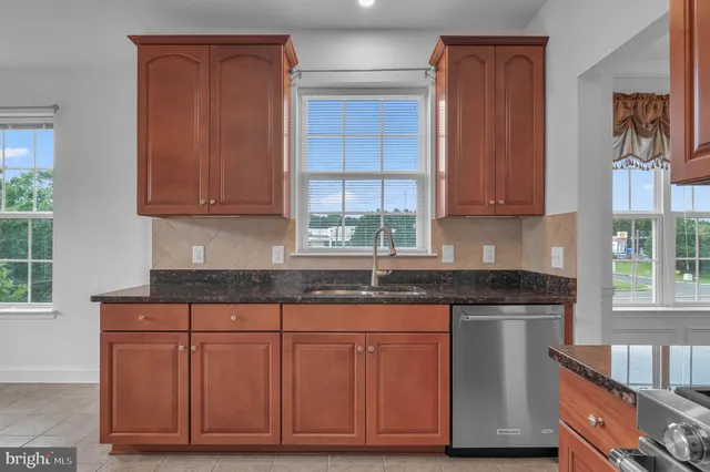 a kitchen with granite countertop wooden cabinets and a sink