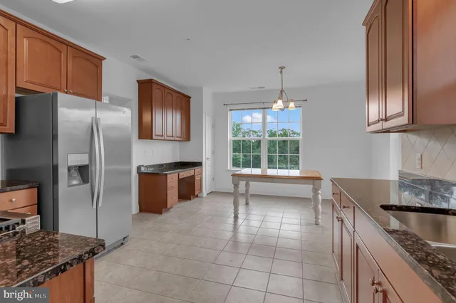 a kitchen with kitchen island granite countertop a sink stove and refrigerator