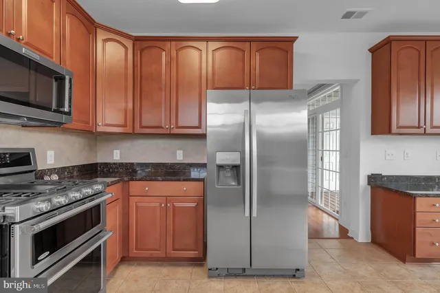 a kitchen with stainless steel appliances granite countertop a refrigerator stove and microwave