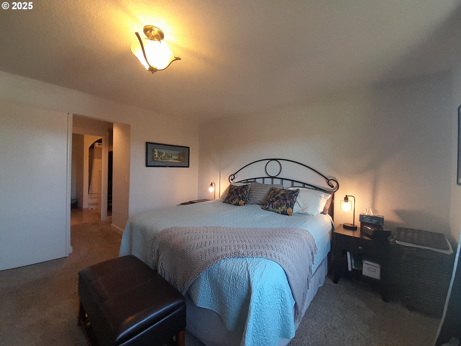 3449 Northeast West Devils Lake Road Lincoln City, OR 97367 - Photo 18 of 48 a bedroom with a bed and a chandelier