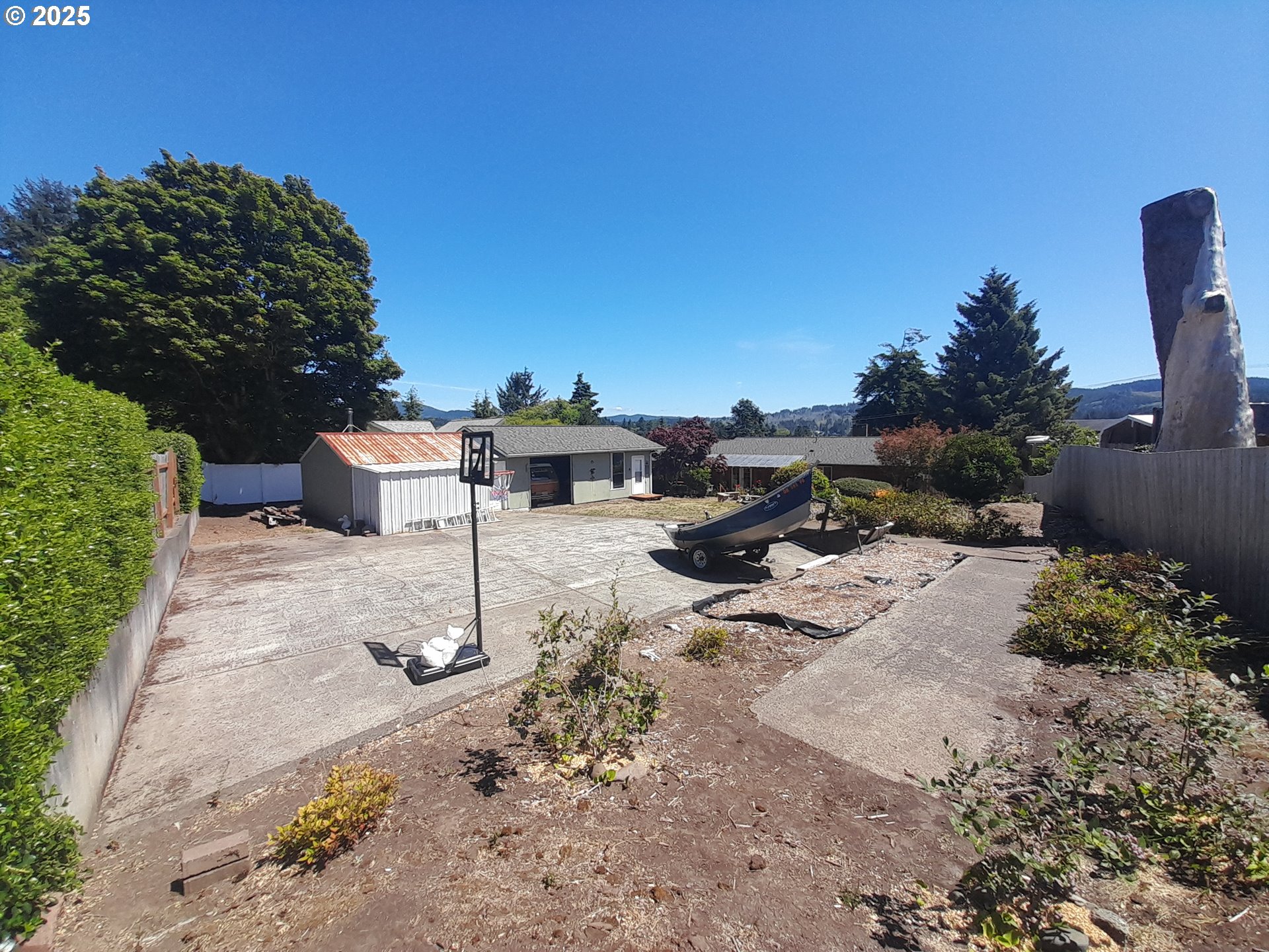 3449 Northeast West Devils Lake Road Lincoln City, OR 97367 - Photo 35 of 48 a view of a backyard with table and chairs a fire pit and large trees