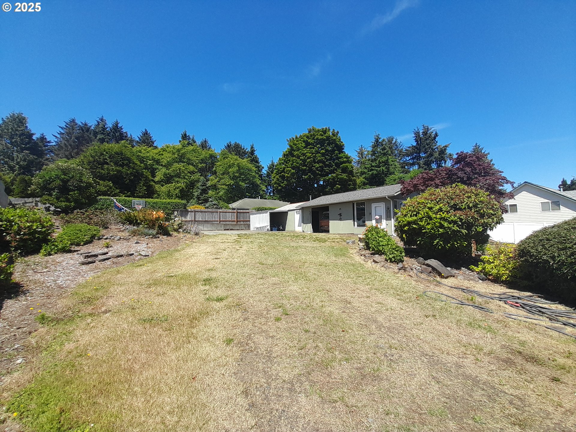 3449 Northeast West Devils Lake Road Lincoln City, OR 97367 - Photo 41 of 48 a front view of a house with a yard and garage