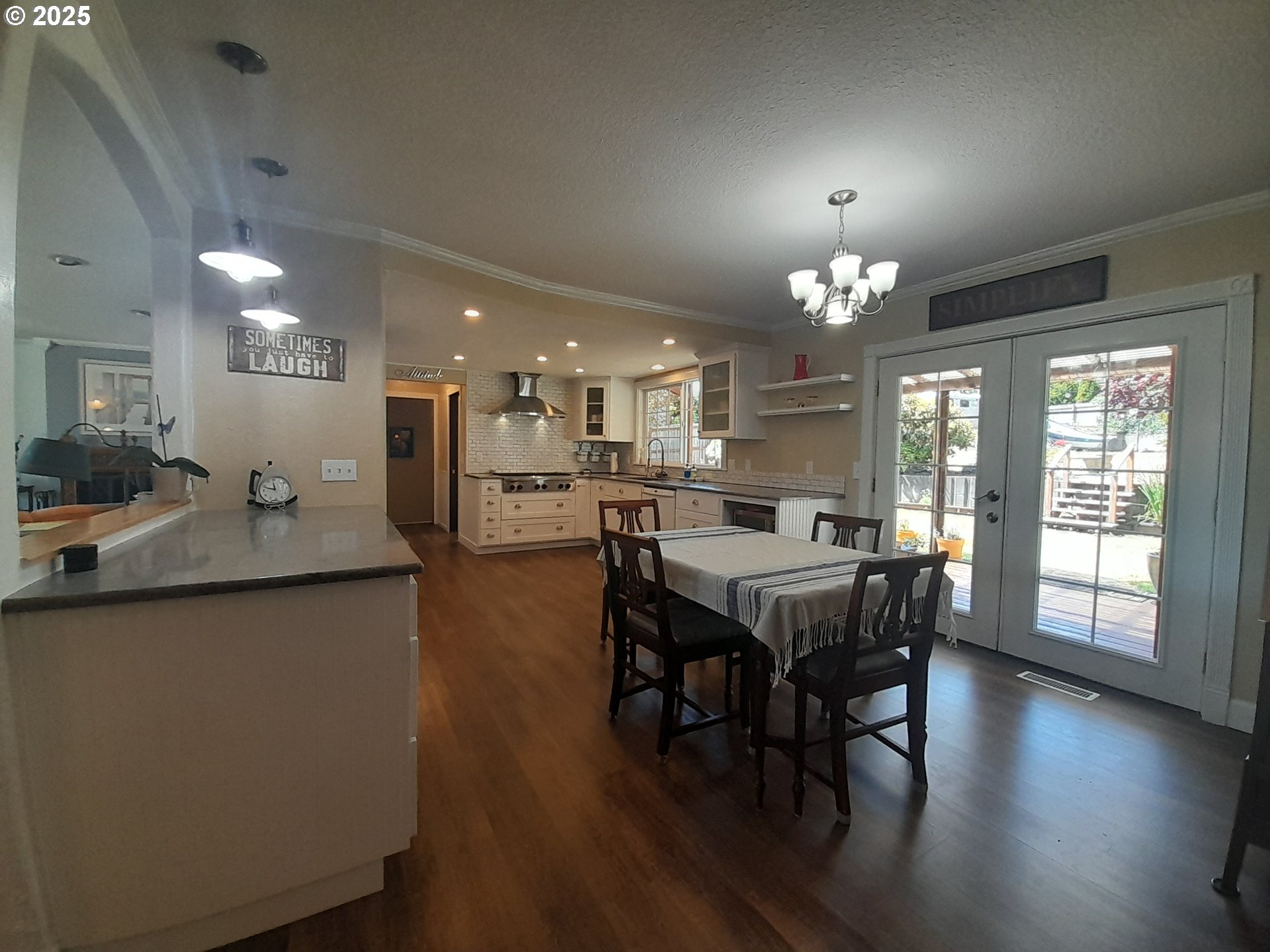 3449 Northeast West Devils Lake Road Lincoln City, OR 97367 - Photo 7 of 48 a dining area with a table chairs and a kitchen view