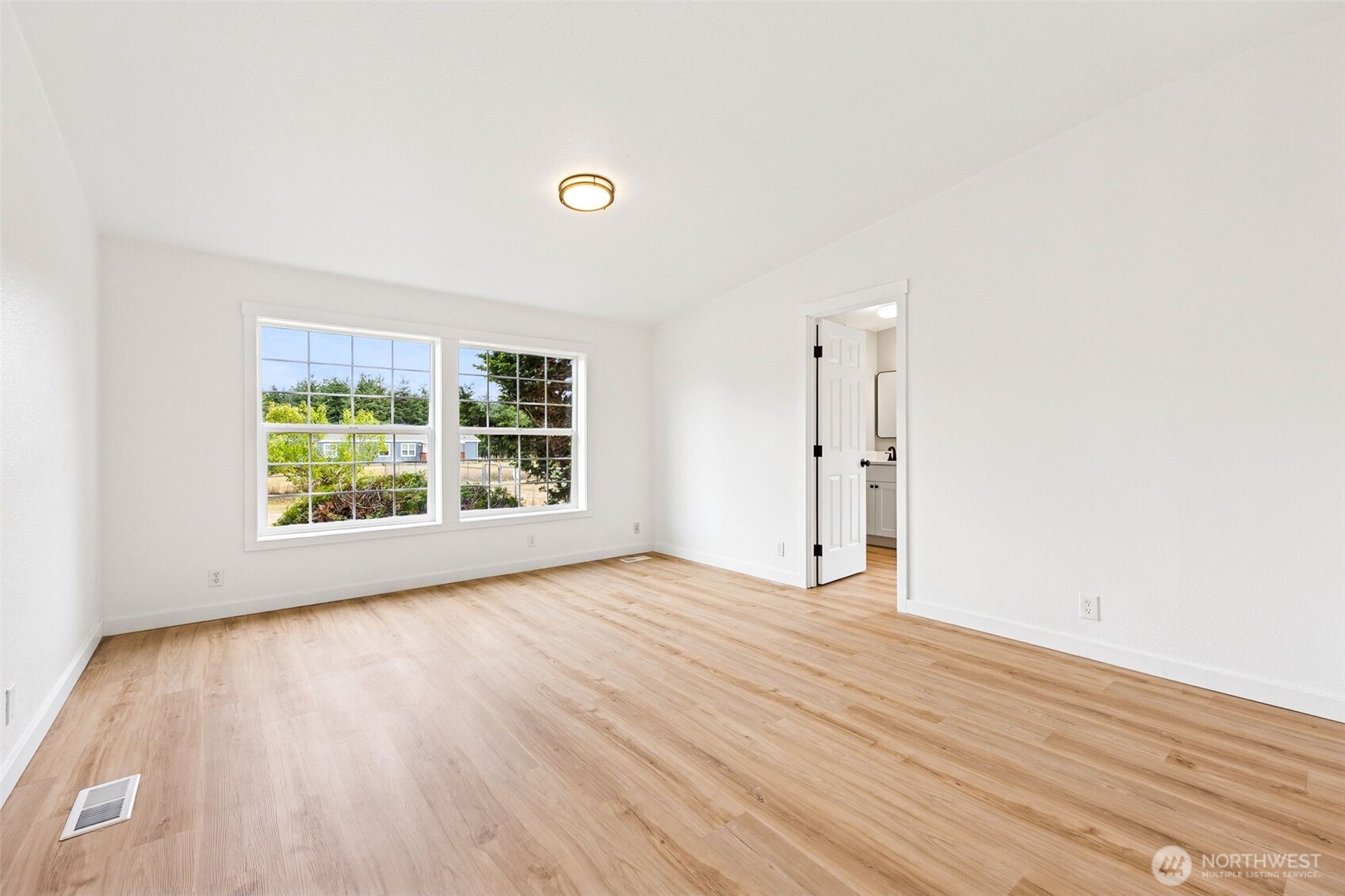 125 Highland Road Winlock, WA 98596 - Photo 19 of 40 an empty room with wooden floor and windows