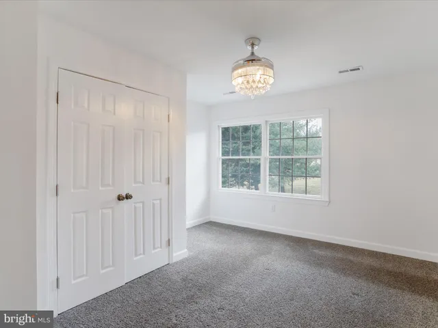 a view of an empty room with a wooden floor and a window
