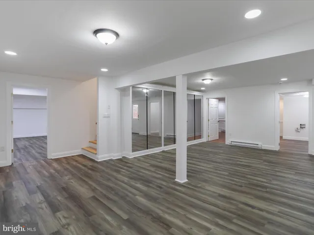a kitchen with white cabinets and window