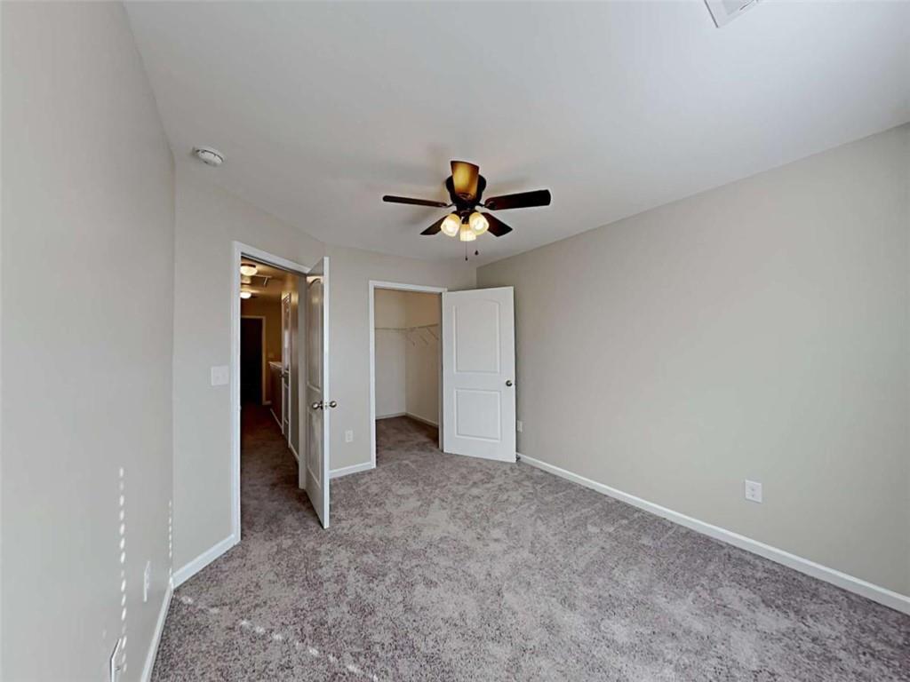 3144 Broadleaf Trail Road Fairburn, GA 30213 - Photo 17 of 21 wooden floor in an empty room with a ceiling fan