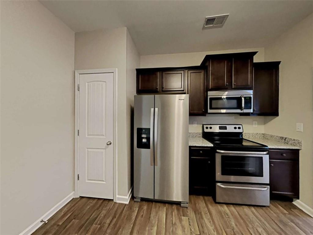 3144 Broadleaf Trail Road Fairburn, GA 30213 - Photo 9 of 21 a kitchen with stainless steel appliances a refrigerator and a stove top oven