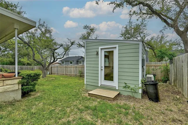 a view of a house with backyard and a tree