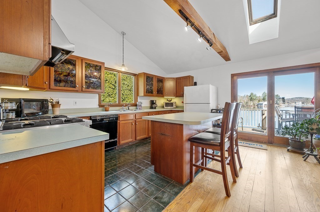 25 Bates Grove Road Webster, MA 01570 - Photo 6 of 42 a kitchen with stainless steel appliances granite countertop a stove a sink a refrigerator a dining table and chairs with wooden floor
