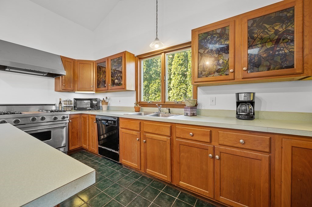 25 Bates Grove Road Webster, MA 01570 - Photo 9 of 42 a kitchen with stainless steel appliances granite countertop a stove a sink dishwasher and white cabinets with wooden floor