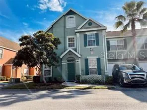 a front view of a house with a garden and trees