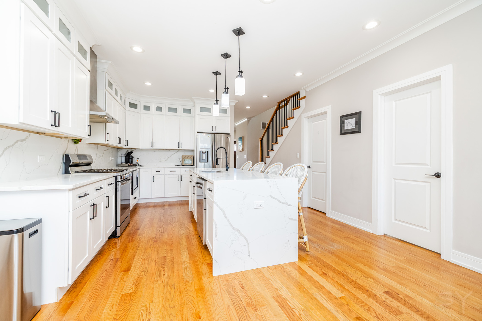 5739 West Grover Street Chicago, IL 60630 - Photo 9 of 38 a large kitchen with stainless steel appliances kitchen island a large counter top a stove and a wooden floors