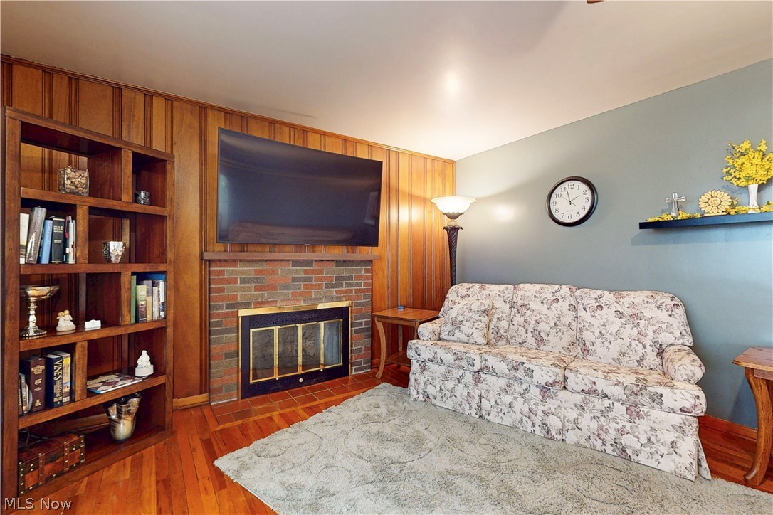 391 Canton Road Steubenville, OH 43953 - Photo 8 of 40 Living room featuring wood finished floors, a fireplace, wooden walls, and built in shelves