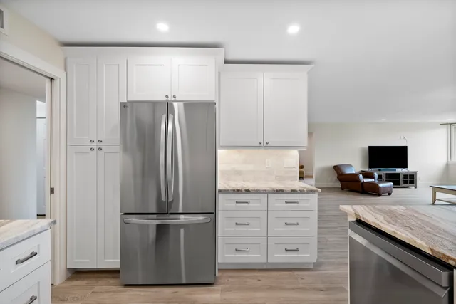 a kitchen with white cabinets and sink