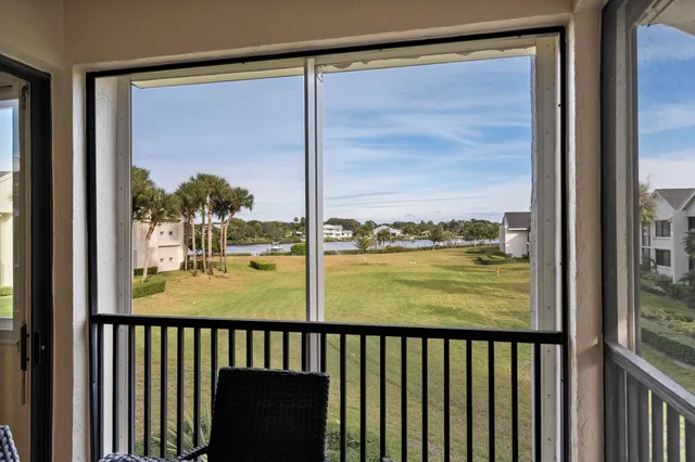 a living room with furniture and a large window with balcony view