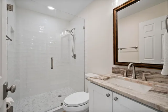 a spacious bedroom with a large bed and a chandelier