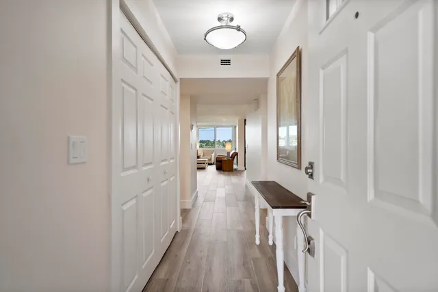 a view of a hallway with wooden floor and staircase