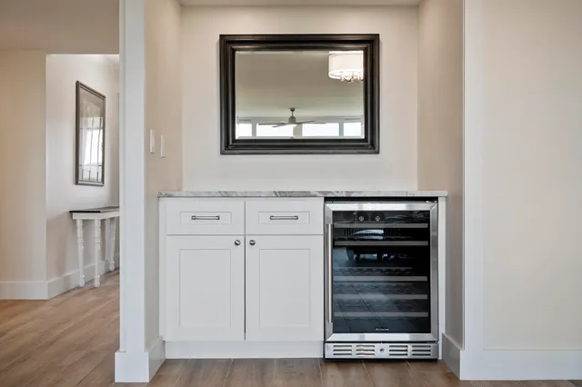 a view of a hallway with wooden floor and cabinet