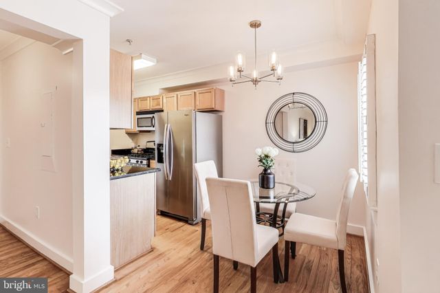 a dining room with furniture a clock and a view of kitchen