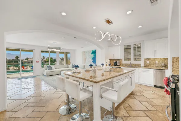 a large kitchen with kitchen island a sink appliances and cabinets