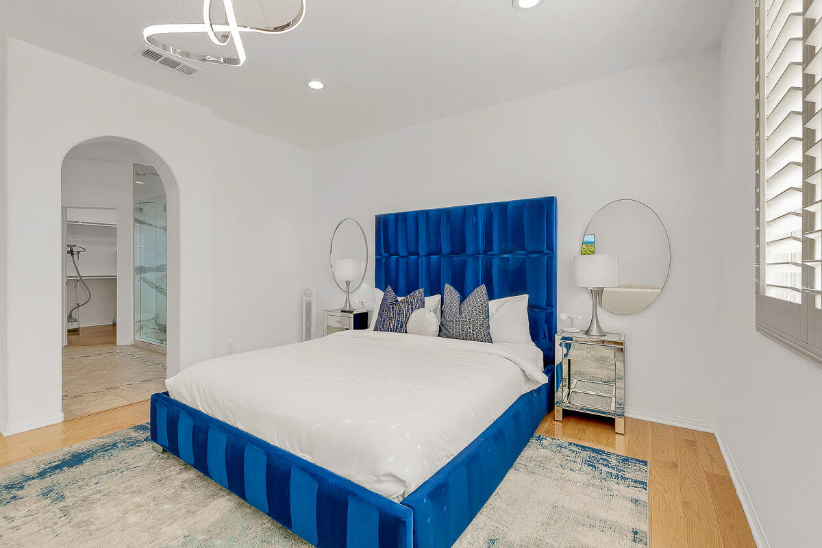 84325 Canzone Drive Indio, CA 92203 - Photo 15 of 53 a bedroom with a bed and a chandelier