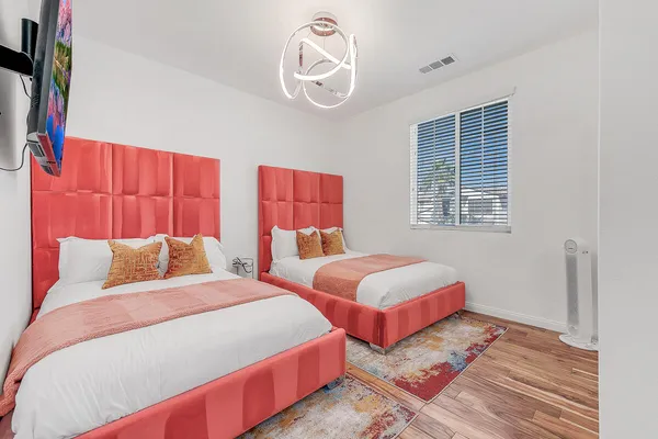 a bedroom with two beds and a chandelier