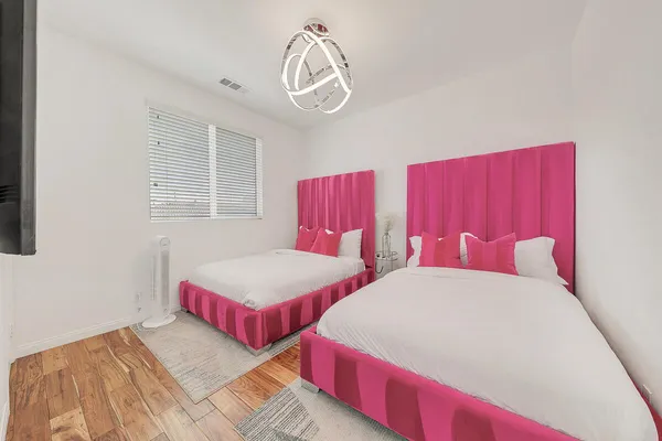 a bedroom with two beds and a chandelier