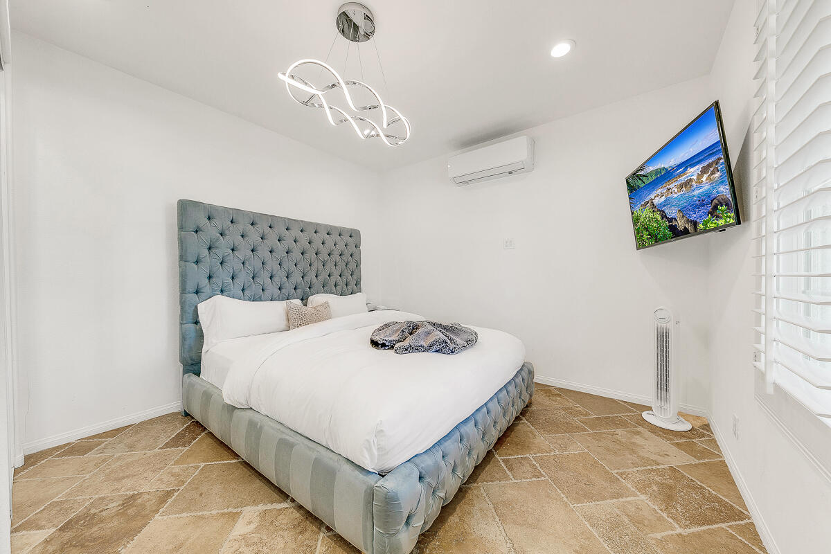 84325 Canzone Drive Indio, CA 92203 - Photo 27 of 53 a bedroom with a bed and a chandelier