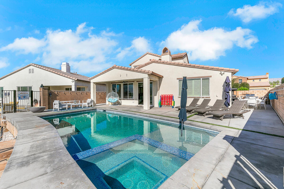 84325 Canzone Drive Indio, CA 92203 - Photo 32 of 53 a view of a patio with swimming pool table and chairs