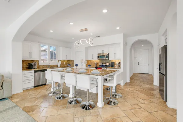 a kitchen with stainless steel appliances kitchen island granite countertop a sink and cabinets