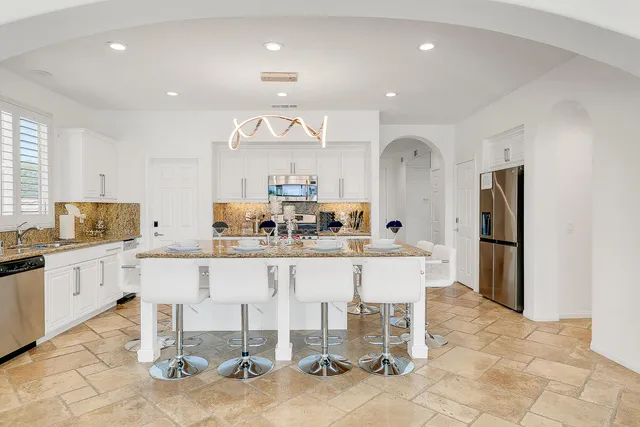 a large white kitchen with a table and chairs