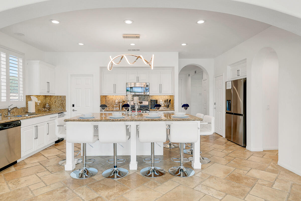 84325 Canzone Drive Indio, CA 92203 - Photo 6 of 53 a large white kitchen with a table and chairs