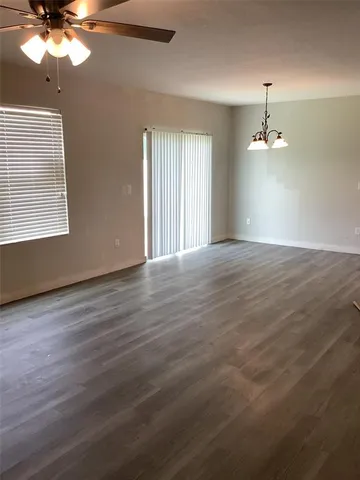 a view of a room with wooden floor and a ceiling fan