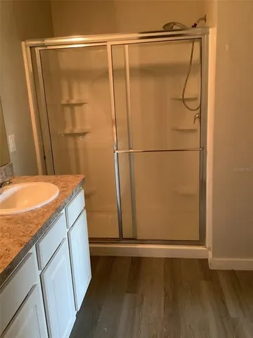 a bathroom with a granite countertop shower and a sink