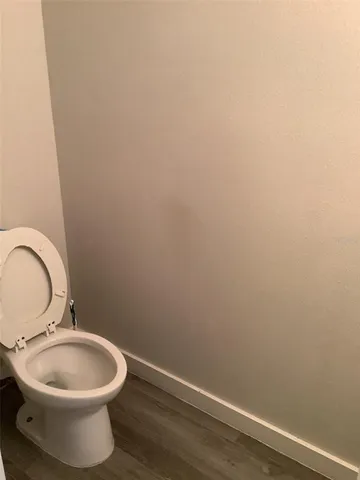 an empty room with wooden floor and fan