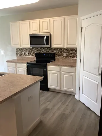a kitchen with cabinets appliances and a window