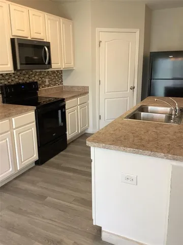 a kitchen with a sink stove and microwave