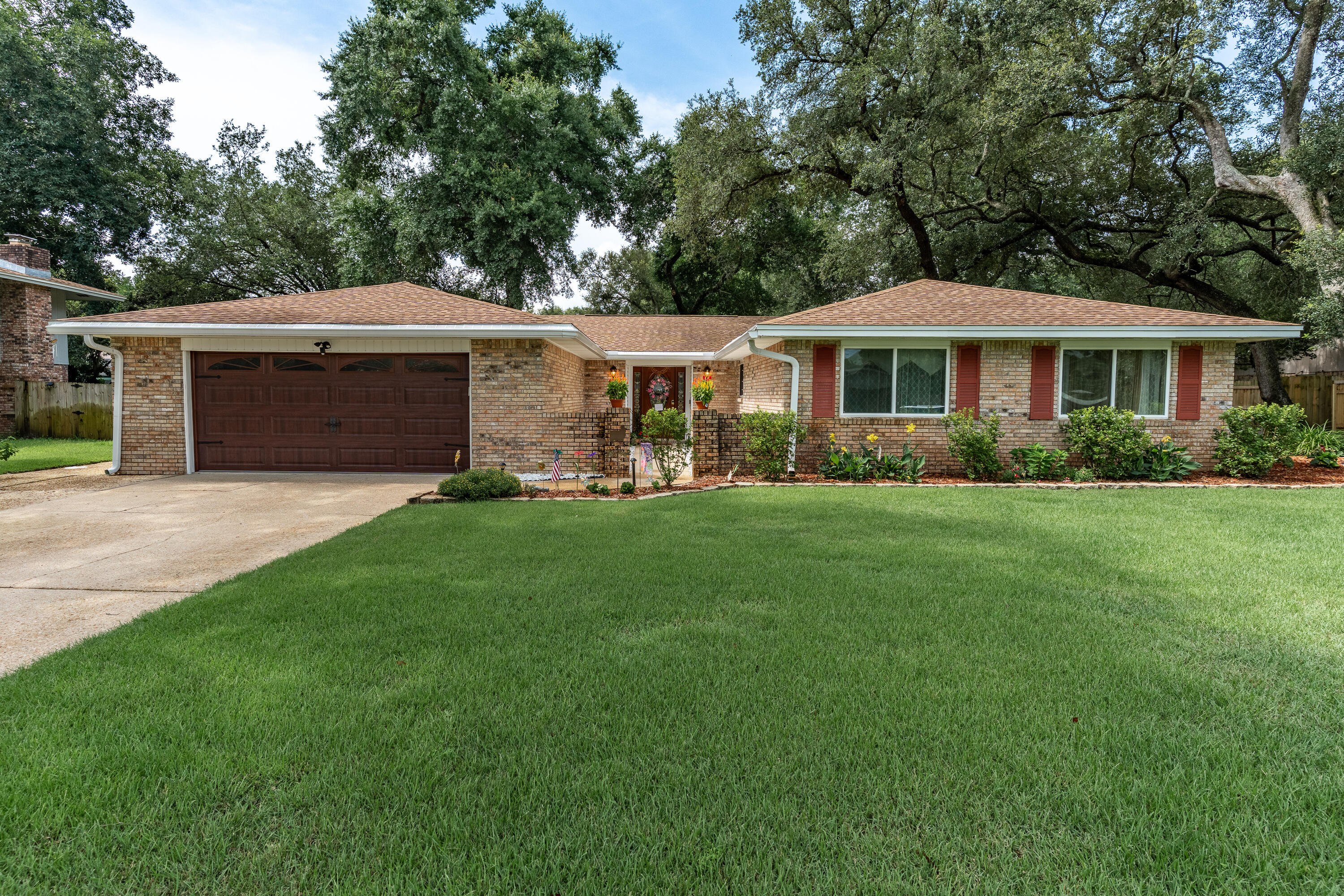 149 Raintree Boulevard Niceville, FL 32578 - Photo 2 of 72 a front view of a house with a garden and trees