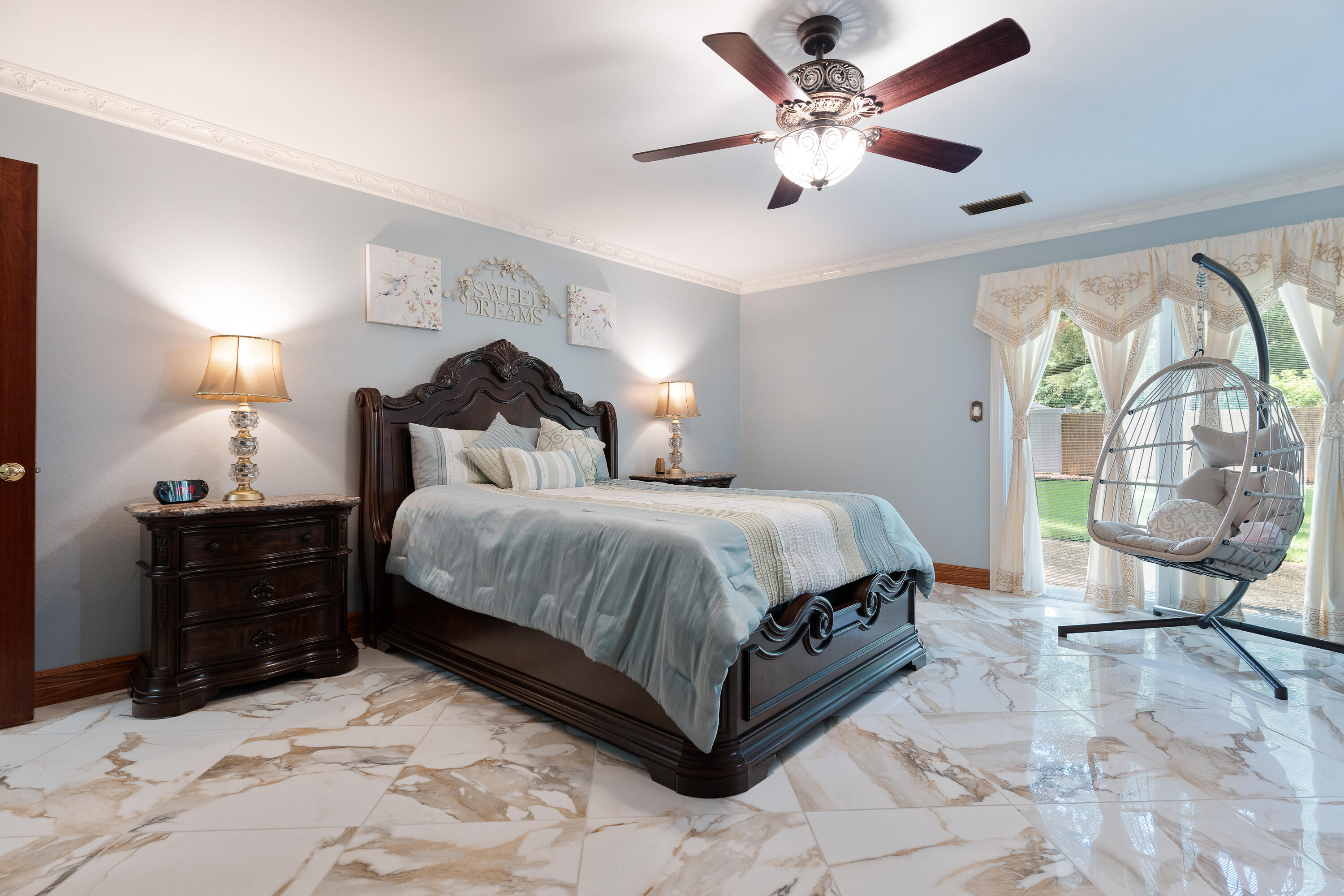 149 Raintree Boulevard Niceville, FL 32578 - Photo 29 of 72 a spacious bedroom with a bed a dresser and a chandelier