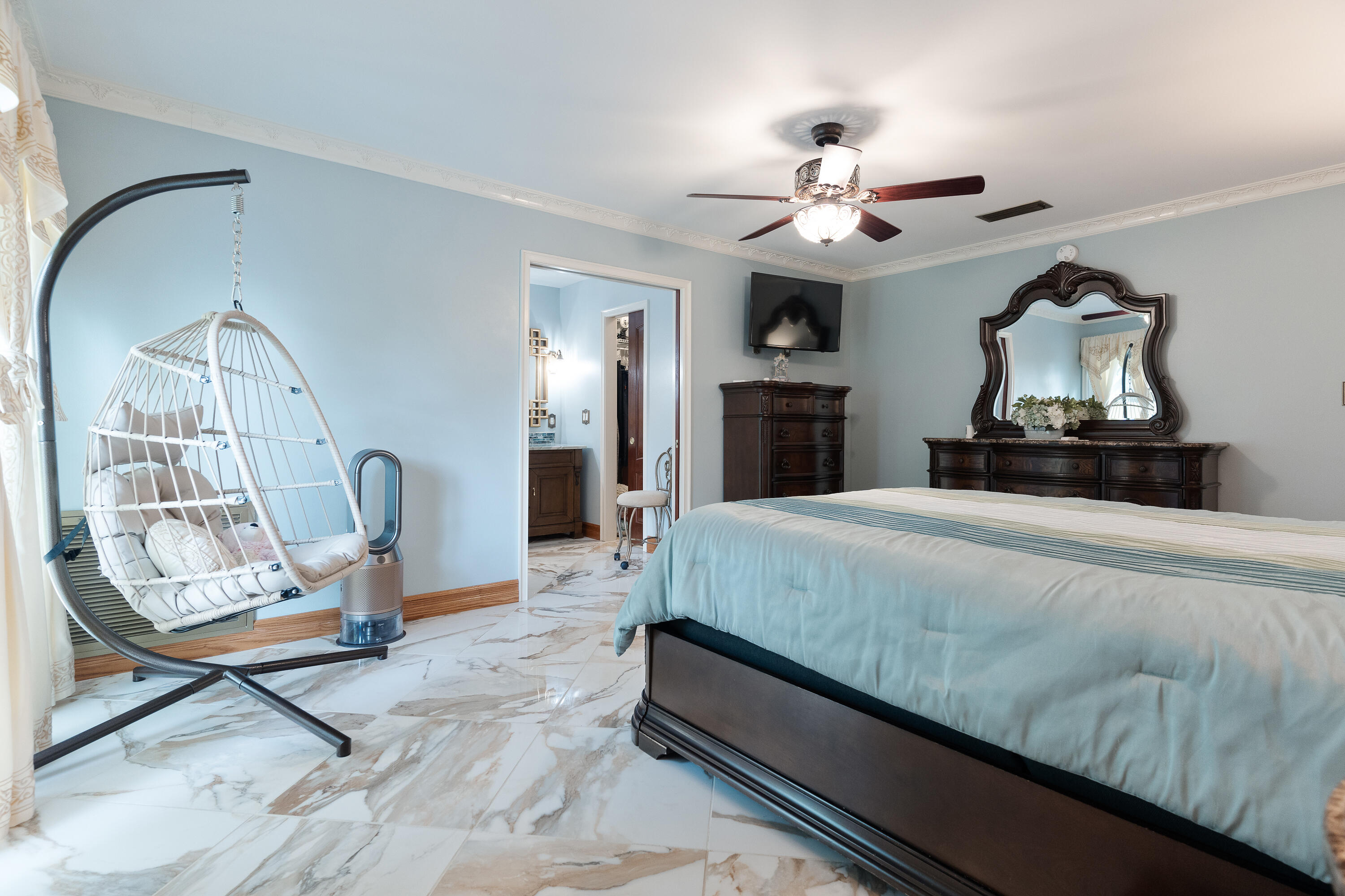 149 Raintree Boulevard Niceville, FL 32578 - Photo 30 of 72 a bedroom with a bed a chandelier and mirror