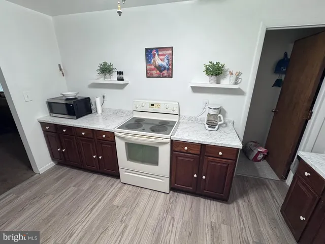 a kitchen with a sink and wooden floor