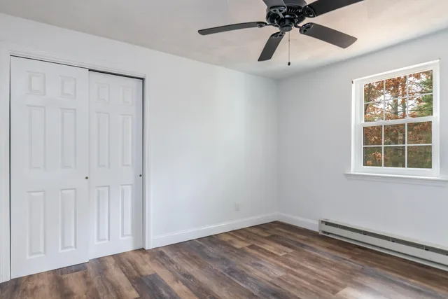 an empty room with a window and a fan
