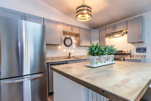 a kitchen with a table chairs and white cabinets