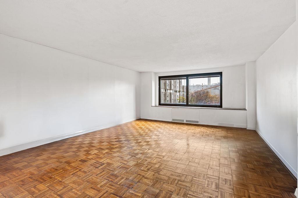 531 Main Street, Unit 504 Manhattan, NY 10044 - Photo 3 of 14 a view of an empty room with window and wooden floor
