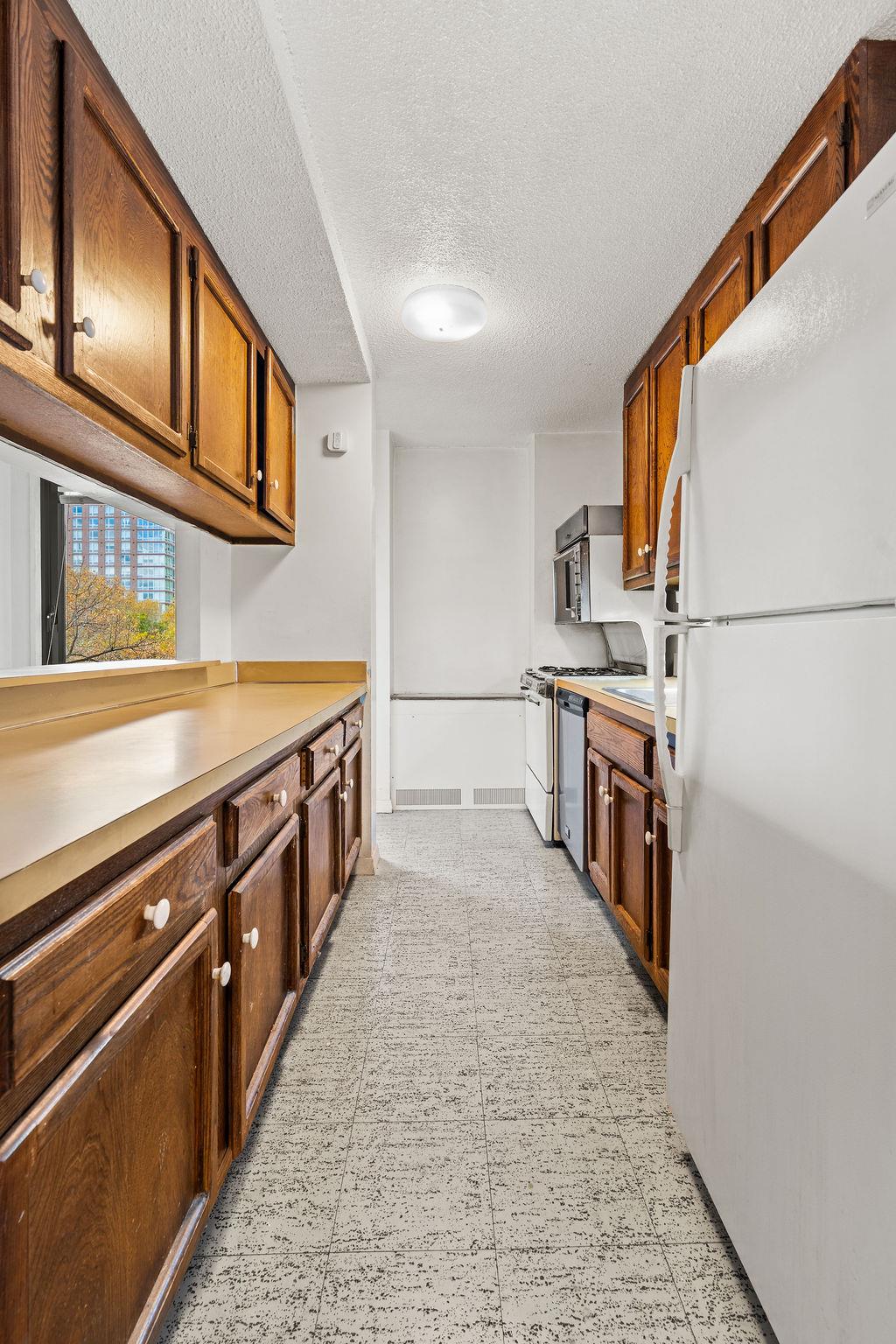531 Main Street, Unit 504 Manhattan, NY 10044 - Photo 7 of 14 a kitchen with stainless steel appliances granite countertop a stove a sink and a refrigerator