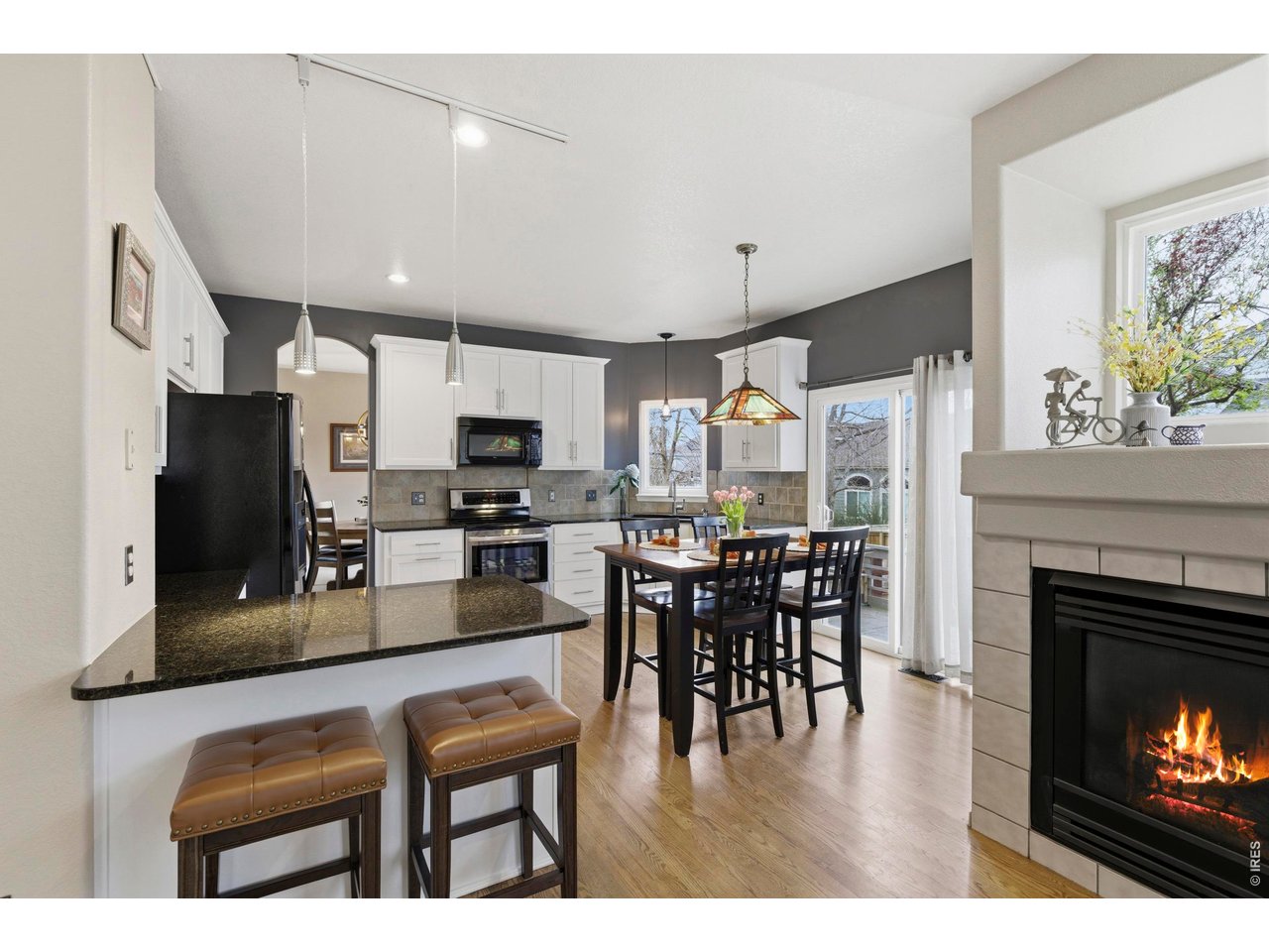 9734 Red Oakes Drive Highlands Ranch, CO 80126 - Photo 11 of 40 a kitchen with stainless steel appliances granite countertop a stove refrigerator a dining table and chairs with wooden floor