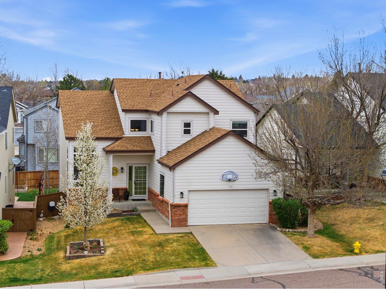 9734 Red Oakes Drive Highlands Ranch, CO 80126 - Photo 2 of 40 a view of a white house next to a yard with large trees
